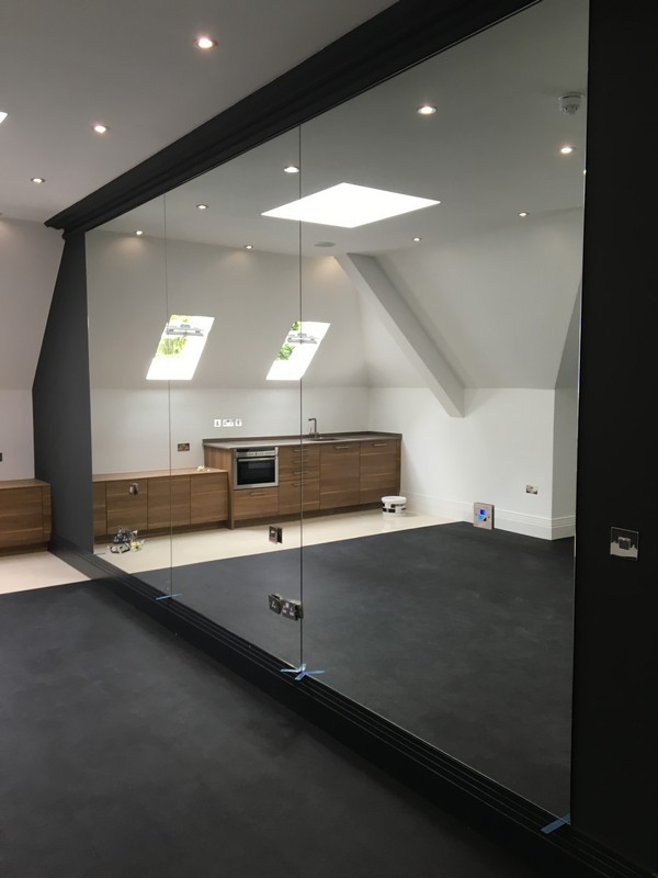 Frameless glass partition in loft conversion by Rotherhithe glaziers